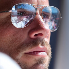  Focused man working on laptop outdoors with screen reflected in sunglasses