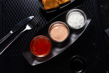 Assorted Sauces in Black Tray on Dark Table, Top View