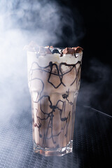 Chocolate Milkshake with Whipped Cream and Chocolate in Glass on Dark Table, Top View