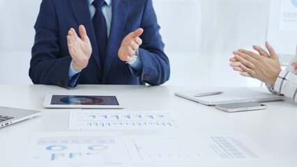 Professional business team clapping hands, celebrating successful presentation, showcasing collaborative spirit and corporate achievement in modern meeting space