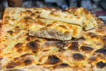 Close-up of freshly baked focaccia bread with golden crust, cut into slices and stacked on top. Foo, bread concept