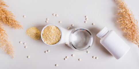 Health food with peptides and water in a glass on the table top view web banner