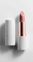 A single tube of lipstick with a light pink hue rests beside its white cylindrical case against a stark white background.  The image is clean and well-lit