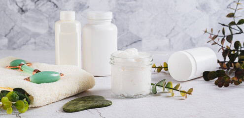 Beef tallow for skin care in a jar and massagers on the table web banner