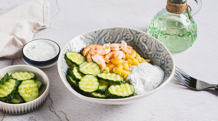 Bowl with pasta, shrimp, cucumber and sauce on the table web banner