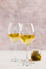 White wine infused with jalapeno slices in glasses on the table vertical view