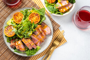 A plate of meat and vegetables with a fork and knife on a table