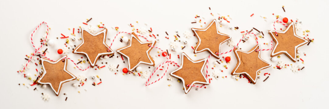 A row of gingerbread stars with red icing and sprinkles