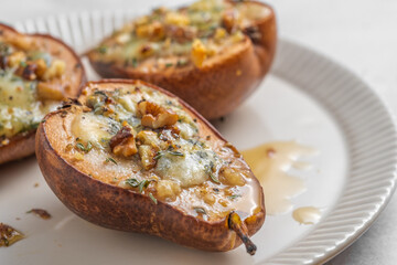 A plate with three baked pears with a white sauce on top