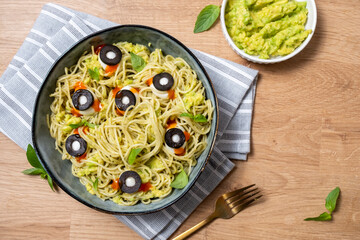 A bowl of pasta with olives and cheese on top