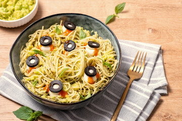 A bowl of pasta with olives and sauce