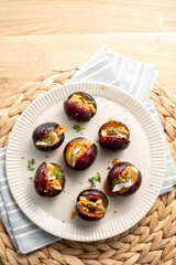 A white plate with a bunch of plum halves on it