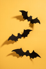 Naklejka premium Three black bats are hanging from the ceiling