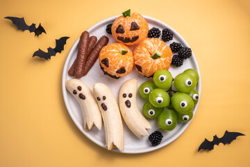 A plate of Halloween themed fruit and vegetables