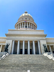 Cuba Capitolio. Neoclassical capitol building in Havana. Grand dome, stone columns and stairs, low angle view. Sunny day, blue sky