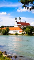 Fototapeta premium Riverfront monastery under a blue sky
