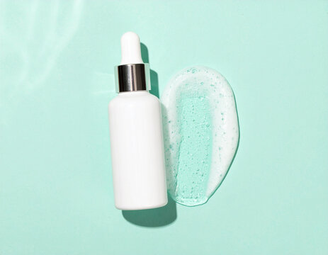 White Dropper Bottle with Silver Accent and Gel Swatch on Mint Background