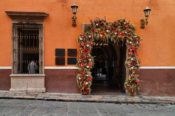 Obraz premium Festive storefront with garland and mannequins in historic center of San Miguel de Allende, Mexico