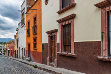 Colonial street with festive wreath and mountain view in historic center of San Miguel de Allende, Mexico