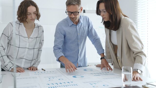 Business team analyzing financial data and discussing growth strategies during a productive meeting in a modern office. Business people concept - Powered by Adobe