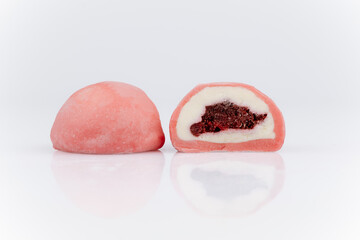 Pink mochi ice cream with berry filling, cut in half, isolated on white background
