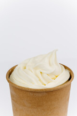 Vanilla soft serve ice cream in an eco paper cup on white background, minimal food concept