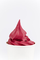 Bright red berry soft serve in white paper cup on white background, minimal food concept