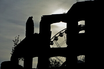 czarne ruiny budynku z oknem o zachodzie słońca, black ruins of building with a window at sunset, walls with window openings of a ruined house on the background of sunset, okno z widokiem na karuzelę © kateej
