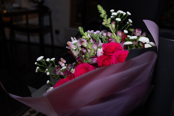 Vibrant bouquet of roses and assorted flowers wrapped in elegant paper, showcasing beauty and celebration, perfect for gifting on special occasions with copy space