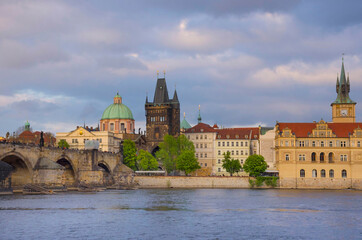 Charles Bridge (Karluv Most) on Vltava river and Old Town Bridge Tower, famous tourist destination in Prague, Czech Republic (Czechia), at sunset