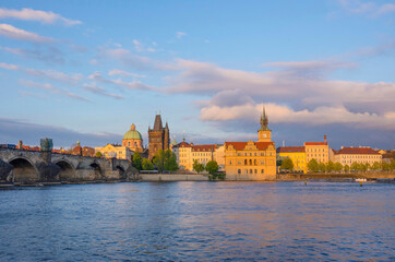 View of old town with Charles Bridge (Karluv Most) on Vltava river and Old Town Bridge Tower, famous tourist destination in Prague, Czech Republic (Czechia), at sunset