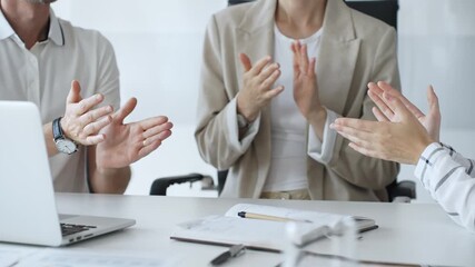 Business team applauding after achieving a goal during a productive meeting in a modern office environment, celebrating success and teamwork, close up