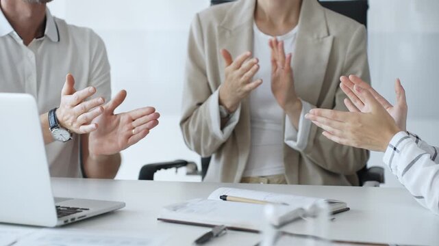 Business team applauding after achieving a goal during a productive meeting in a modern office environment, celebrating success and teamwork, close up