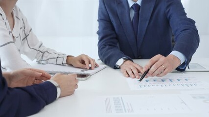 Corporate team reviewing financial data, collaborating around digital tablet and paperwork, analyzing market trends in modern office setting with professional demeanor - Powered by Adobe