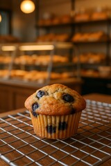 Delicious blueberry muffin cooling on a rack in a bakery. Freshly baked pastry perfect for breakfast or a sweet treat.