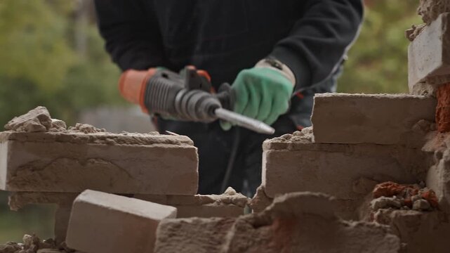 A construction worker is using a power tool on a brick wall to enhance the structure