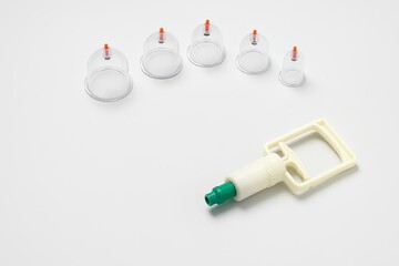 Cupping set with various sized cups and suction pump on white background. Traditional therapy tools for alternative medical treatment. Hijama, treatment according to the Sunnah.
