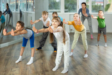 Girl participates in childrens group lesson, learning to dance twerk. Devotion of modern trend...