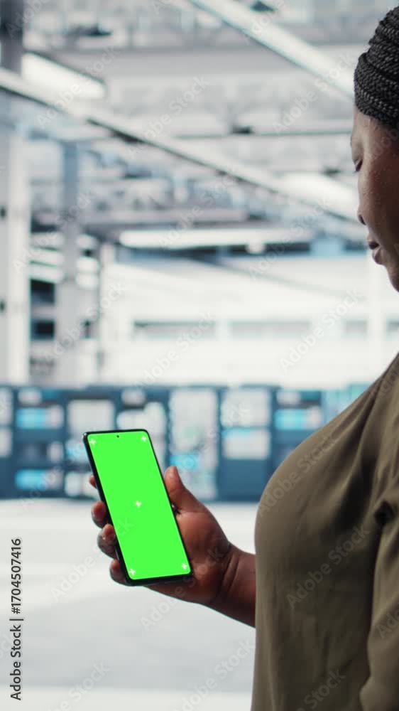 Poster vertical video worker using app on mockup phone to check server hub energy consumption. admin using 