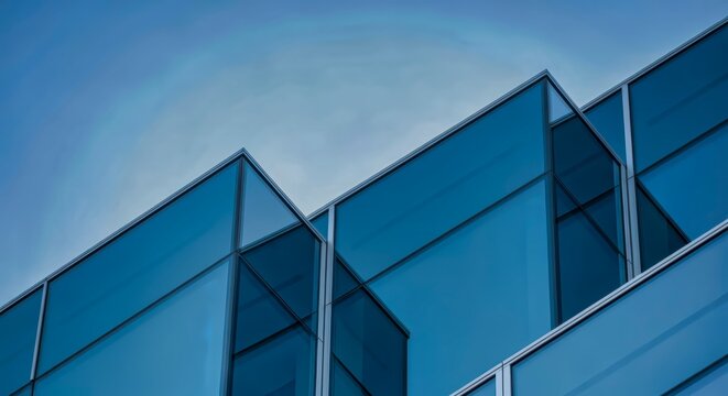 Modern Architectural Design: Glass Facade Building Against a Clear Sky Backdrop
