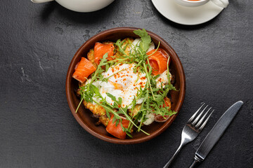 Healthy brunch with poached egg, smoked salmon and fresh arugula on a vegetable fritter