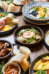 Delicious variety of gourmet breakfast dishes served on wooden table in cozy restaurant