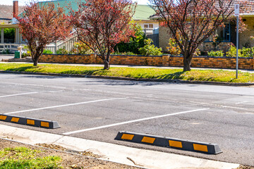 Wheel stops in marked parking bays on suburban residential street in Melbourne, Australia, with...