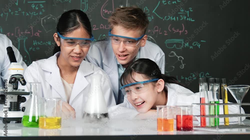 Poster girl looking at beaker while doing experiment at blackboard with chemistry theory in stem class. tea