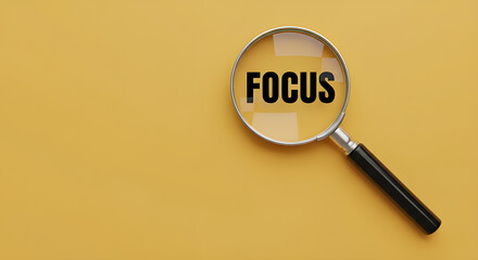 Magnifying glass focusing on the word 'FOCUS' on a yellow background.