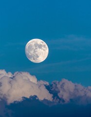 Full moon illuminating clouds in a serene night sky