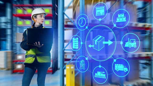 Female warehouse worker in helmet and vest using laptop with logistics icons, symbolizing digital supply chain management and smart warehouse technology. Warehouse, Logistics,