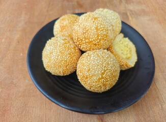 fried potatoes on a frying pan,Sesame balls or Onde onde or Jiandui or Kue moci or Kuih bom,a type of Chinese pastry,made from glutinous rice,coated with sesame seeds,filled with a filling usually bea