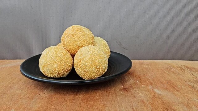 cookies on a plate,Sesame balls or Onde onde or Jiandui or Kue moci or Kuih bom,a type of Chinese pastry,made from glutinous rice,coated with sesame seeds,filled with a filling usually beans,served wi