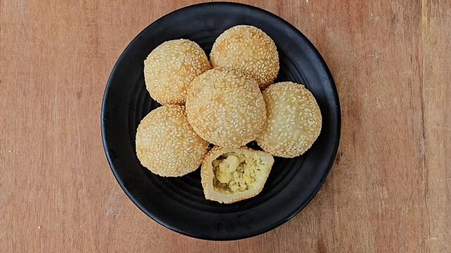 cookies on a plate,Sesame balls or Onde onde or Jiandui or Kue moci or Kuih bom,a type of Chinese pastry,made from glutinous rice,coated with sesame seeds,filled with a filling usually beans,served wi